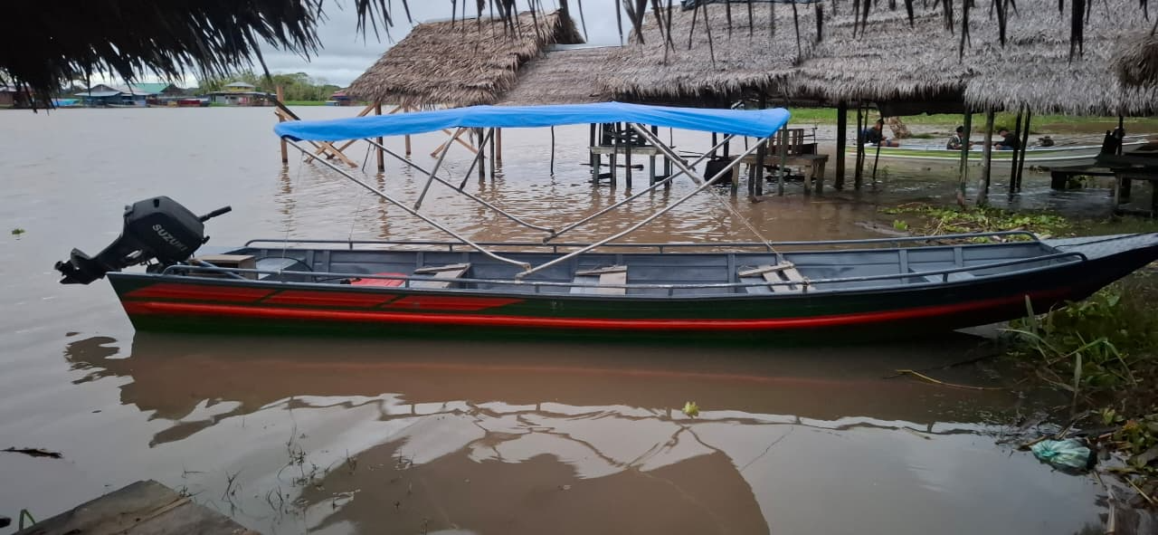Embarcación con motor fuera de borda sobre un río del Amazonas, utilizada como referencia de transporte fluvial regional